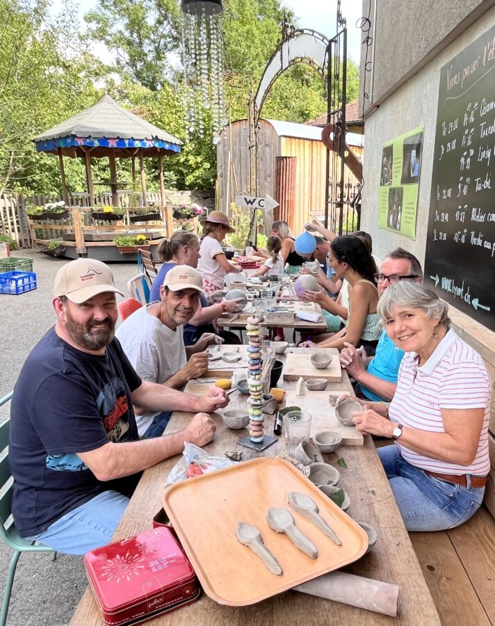 une dizaine de personnes autour d'une table qui font de la céramique
