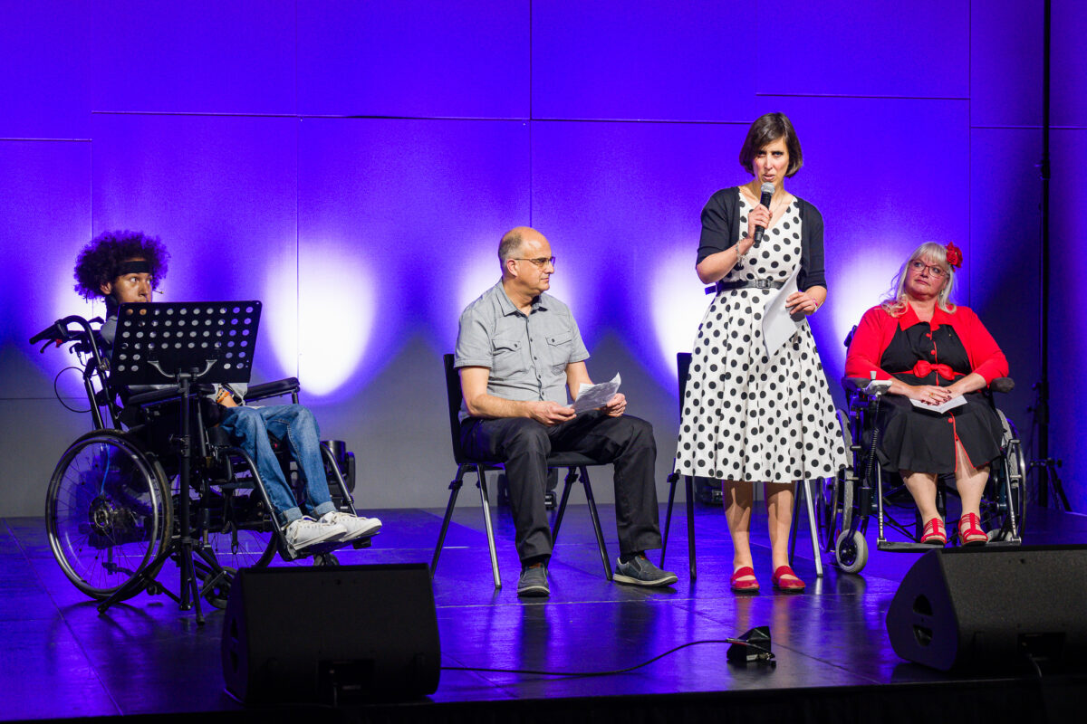 Aux côtés de Malick Reinhart, des personnes en situation de handicap, Céline Witschard, fondatrice de Vision positive, Cédric Goedecke, pair praticien, et Corinne Bonnet-Mérier, Présidente du Club en fauteuil roulant Genève, sont sur scène pour livrer leurs témoignages.