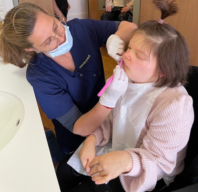 Une dentiste pratique des soins dentaire à une jeune femme